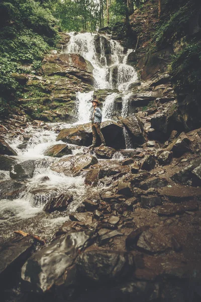 Stijlvolle Hipster Man Hat Met Fotocamera Permanent Bij Waterval Forest — Stockfoto