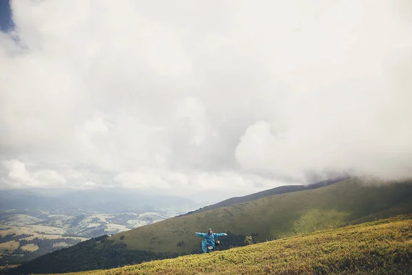 여행과 개념입니다 여행자 Hipster 파란색 비옷에 텍스트를 공간입니다 순간입니다 언덕에 — 스톡 사진