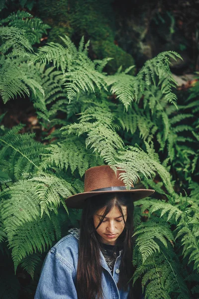 Κομψό Hipster Κορίτσι Στο Καπέλο Που Κάθεται Θάμνους Φτέρη Ανάμεσα — Φωτογραφία Αρχείου