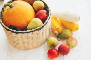 Mutlu Şükran günleri. Kabak ve elma ve armut beyaz ahşap zemin üzerinde şık hasır sepet içinde kabak