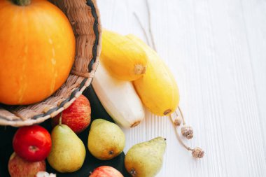 Mutlu Şükran günleri. Kabak ve elma ve armut beyaz ahşap zemin üzerinde şık hasır sepet içinde kabak