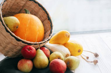 Mutlu Şükran günleri. Kabak ve elma ve armut beyaz ahşap zemin üzerinde şık hasır sepet içinde kabak