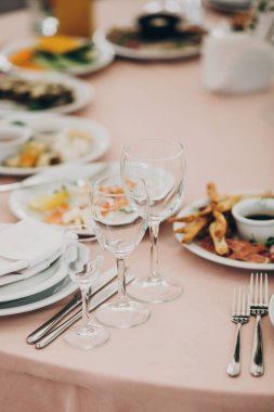 şık düğün ayarlama, şarap gözlük, çatal bıçak takımı, peçete ve lezzetli yiyecek ve içecekler ile ihale pembe tablo.