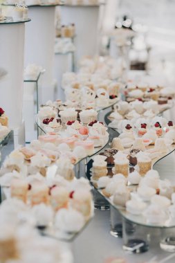 kutlama modern tatlı masasında. lezzetli kek, kurabiye, kek meyve pembe ve beyaz renklerde şık şeker çubuk. lüks restoranda yemek. Düğün