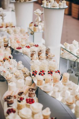 lezzetli kek, kurabiye, kek meyve pembe ve beyaz renklerde şık pembe şeker bar masa. lüks restoranda yemek. modern düğün. tatlı tablo