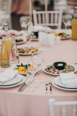 şık düğün ayarlama, şarap gözlük, çatal bıçak takımı, peçete ve lezzetli yiyecek ve içecekler ile ihale pembe tablo.