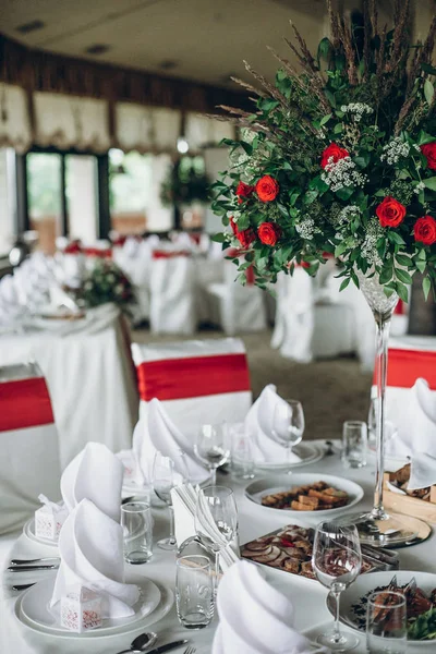 赤いバラの装飾と白い絹の椅子とナプキンとエレガントな結婚式のテーブル 高級レストランでの結婚披露宴のケータリング — ストック写真
