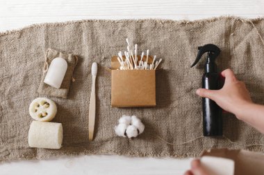 Holding doğal çevre bambu diş fırçası, Hindistan cevizi sabun, el yapımı şampuan, kristal deodorant, lif kabağı, bambu kulak sopa ver. sıfır atık kavramı, sürdürülebilir yaşam tarzı düz yatıyordu