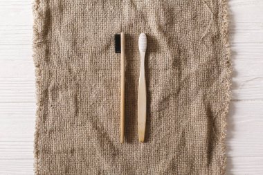 Eko doğal bambu diş fırçaları düz rustik arka plan üzerinde yatıyordu. sürdürülebilir yaşam tarzı kavramı. sıfır atık. Plastik ücretsiz öğeler. Plastik kirliliği durdurmak. yeniden, azaltmak, geri dönüşüm, reddetme
