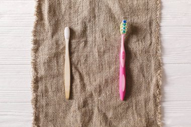 sürdürülebilir yaşam tarzı kavramı. sıfır atık. Eko doğal bambu diş fırçası rustik arka plan üzerinde plastik diş fırçası ile. Plastik kirliliği durdurmak. yeniden, azaltmak, geri dönüşüm, reddetme