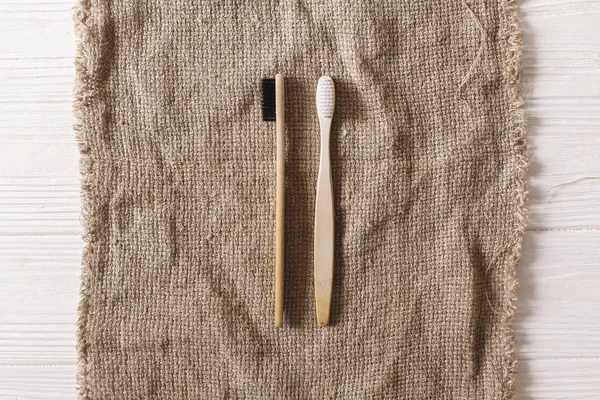 eco natural bamboo toothbrushes flat lay on rustic background.  sustainable lifestyle concept. zero waste. plastic free items. stop plastic pollution. reuse, reduce, recycle, refuse