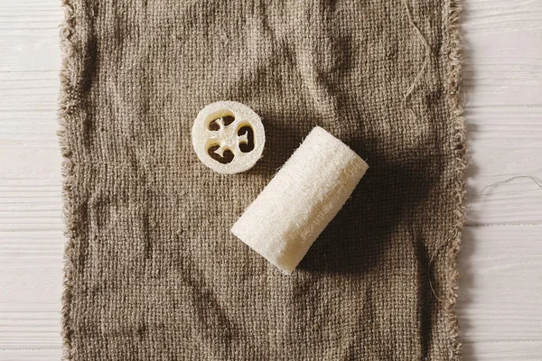 eco natural luffa brush  flat lay on rustic background.  sustainable lifestyle concept. zero waste. plastic free items. stop plastic pollution. reuse, reduce, recycle, refuse