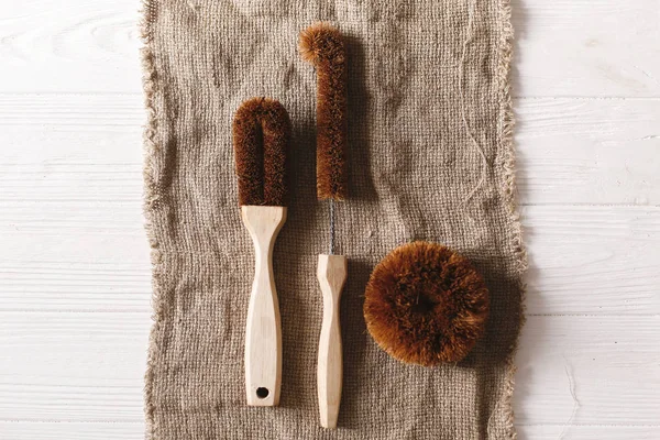 Eko doğal Hindistan cevizi fırçaları düz rustik arka plan üzerinde yatıyordu. sürdürülebilir yaşam tarzı kavramı. sıfır atık. Plastik ücretsiz öğeler. Plastik kirliliği durdurmak. yeniden, azaltmak, geri dönüşüm, reddetme