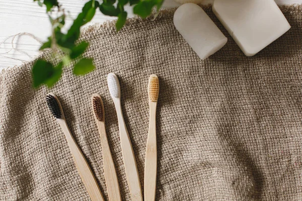 Eko doğal bambu diş fırçaları rustik yeşil zemin üzerine. sürdürülebilir yaşam tarzı kavramı. sıfır atık düz yatıyordu. banyo temel, plastik ücretsiz öğeler
