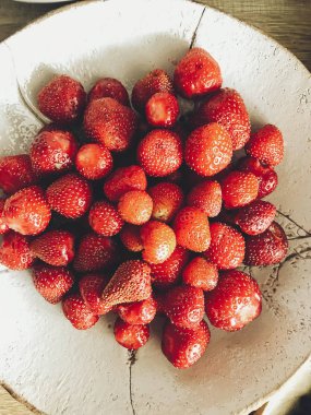taze yaz meyve mutfak ahşap masa üzerinde seramik kase. Olgun çilek piyasadan. sıfır atık. düz lay