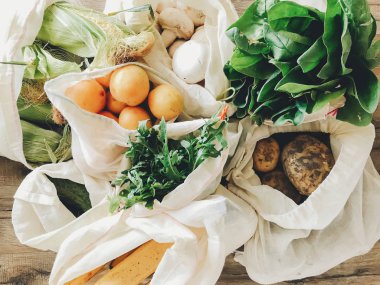 taze sebze mutfakta masada Eko pamuk torbalarda. marul, Mısır, patates, kayısı, muz, rucola, mantar piyasadan. sıfır atık alışveriş kavramı. Ban plastik