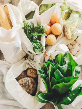 taze sebze mutfakta masada Eko pamuk torbalarda. marul, Mısır, patates, kayısı, muz, rucola, mantar piyasadan. sıfır atık alışveriş kavramı. Ban plastik