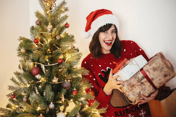 Glückliche Junge Frau Mit Weihnachtsmannmütze Die Einen Stapel Von Geschenkboxen — Stockfoto