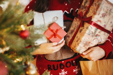 birçok Noel hediye kutuları altın güzel Noel ağacı, elinde Festival odasında ışıklı. kış tatili atmosferik anlar. mevsim selam. Mutlu Noeller