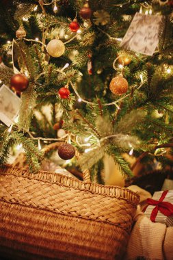 Şık Noel hediyesi süsler, altın ışıkları ile güzel Noel ağacı altında kasa ve festival odasında sunar. çam ağacı dalları üzerinde kırmızı ve altın top. dekor kış tatilleri için