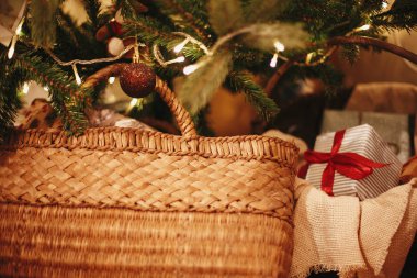 Şık Noel hediye kutuları ve sepet süsleri ile güzel Noel ağacı altında altın ışık ve festival odasında sunar. dalları üzerinde kırmızı ve altın top. dekor kış tatilleri için