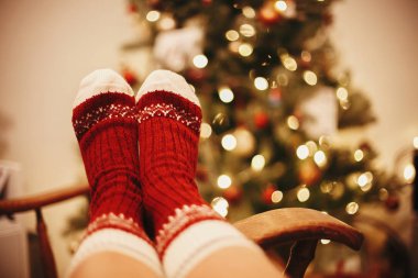 kış tatili rahat. sıcak atmosferik an. Altın güzel Noel ağacı ışıkları Festival odasında ile arka plan üzerinde eski ahşap sandalye şenlikli çorap. zaman rahat ol