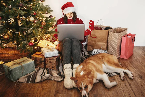 Chica Feliz Sombrero Santa Trabajando Ordenador Portátil Sentado Con Perro —  Fotos de Stock