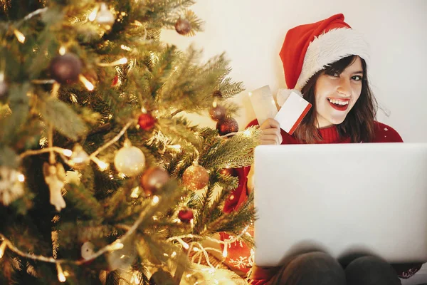 Gyönyörű Fiatal Santa Kalap Holding Hitelkártyát Laptop Golden Gyönyörű Karácsonyfa — Stock Fotó