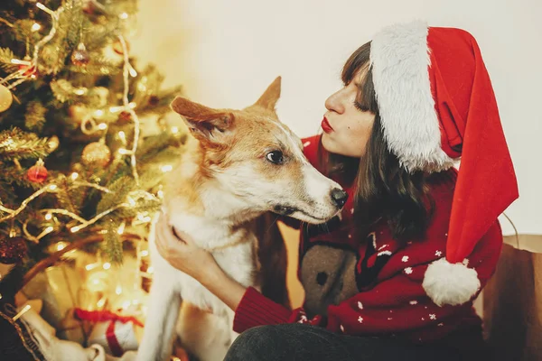 Ευτυχισμένος Κορίτσι Στο Santa Καπέλο Αγκάλιασμα Χαριτωμένο Σκυλί Φόντο Χρυσό — Φωτογραφία Αρχείου