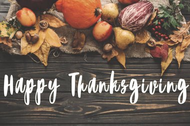 Mutlu Şükran metni kabak, sonbahar sebze ile renkli yaprakları, meşe palamutları, fındık, çilek ahşap rustik masa, düz üzerinde yatıyordu. Mevsim tebrik kartı. Atmosferik görüntü