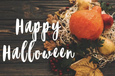 Mutlu Halloween metin kabak, renkli yaprakları, meşe palamutları, fındık, sonbahar sebzeleri güzel kompozisyon üzerinde ahşap rustik masa üzerinde meyveleri. Mevsim tebrik kartı. Atmosferik görüntü