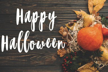 Mutlu Halloween metin kabak, renkli yaprakları, meşe palamutları, fındık, sonbahar sebzeleri güzel kompozisyon üzerinde ahşap rustik masa üzerinde meyveleri. Mevsim tebrik kartı. Atmosferik görüntü