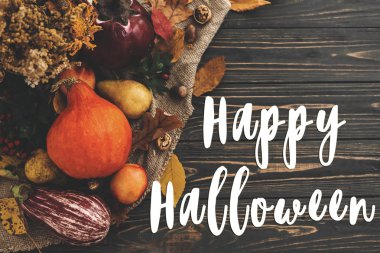 Mutlu Halloween metin kabak, renkli yaprakları, meşe palamutları, fındık, sonbahar sebzeleri güzel kompozisyon üzerinde ahşap rustik masa üzerinde meyveleri. Mevsim tebrik kartı. Atmosferik görüntü