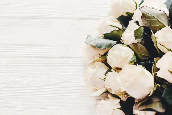 花のグリーティング カードのモックアップ 木製の背景 テキスト用のスペースに白バラ 結婚式招待状または幸せな母の日の概念 白い花の花束 こんにちは春 — ストック写真