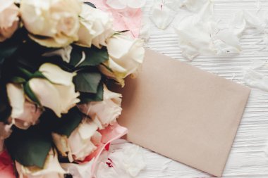 Beyaz güller, düz ahşap arka plan üzerinde boş kart ile metin için yer yatırın. Çiçek tebrik kartı mockup. Düğün davetiyesi, mutlu anne gün kavramı. Sevgililer günü