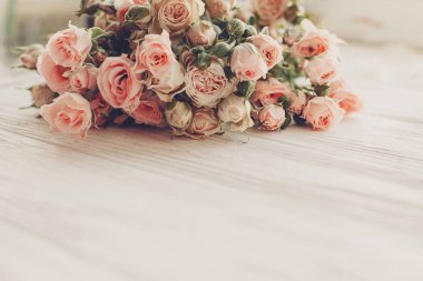 Küçük pembe gül ışık, metin için yer ahşap arka plan üzerinde. Çiçek tebrik kartı mockup. Düğün davetiyesi, mutlu anneler günü ya da Sevgililer günü kavramı. İhale vintage görüntü