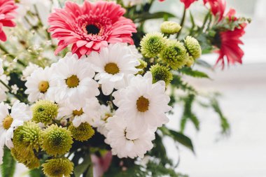 Pembe gerbera, beyaz papatya ve güzel parlak buket ışık rustik pencerede yeşil krizantem. Düğün davetiyesi