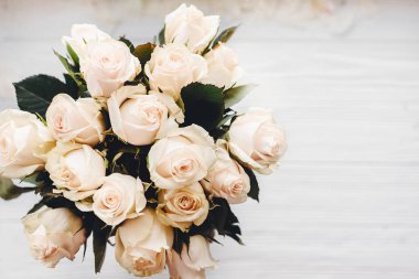 Beyaz ahşap zemin üzerinde beyaz gül buketi. Metin için yer ile üstten görünüm