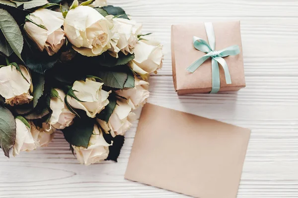 空のカードとギフト ボックス木製の背景 フラットの白バラは テキスト用のスペースに置きます 花のグリーティング カードのモックアップ 結婚式の招待状 幸せな母の日の概念 バレンタインの日 — ストック写真