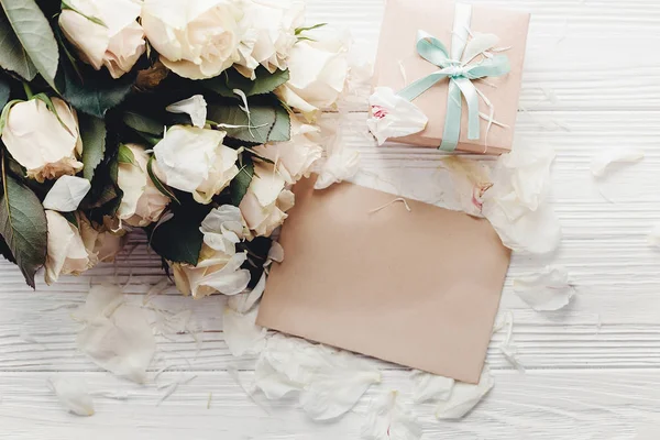 空のカードとギフト ボックス木製の背景 フラットの白バラは テキスト用のスペースに置きます 花のグリーティング カードのモックアップ 結婚式の招待状 幸せな母の日の概念 バレンタインの日 — ストック写真
