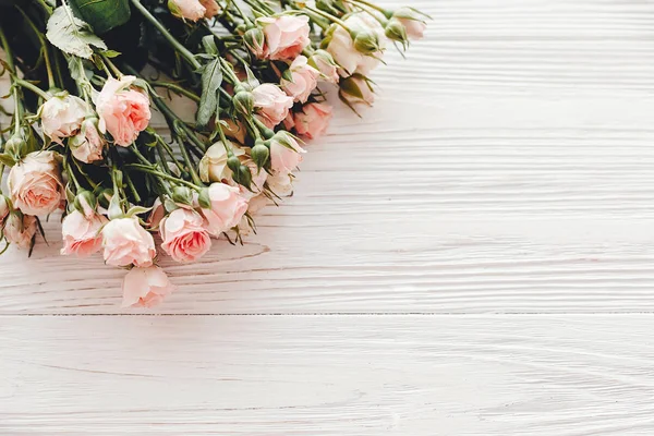 フラット木製の背景にピンクの小さなバラは テキスト用のスペースに置きます 花のグリーティング カードのモックアップ 結婚式招待状 幸せな母の日やバレンタインの日コンセプト こんにちは春 — ストック写真