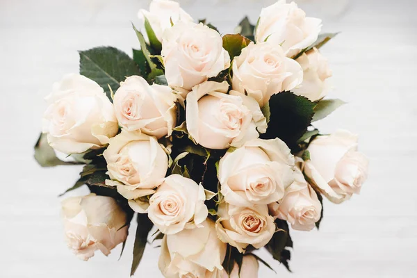 Beyaz ahşap zemin üzerinde beyaz gül buketi. Metin için yer ile üstten görünüm