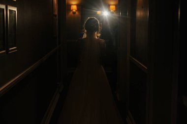 Muhteşem güzel gelin siluet ışık koridorda. Akşam ışığı otel salonunda yürüyüş mutlu şık gelin. Samimiyet kavramı
