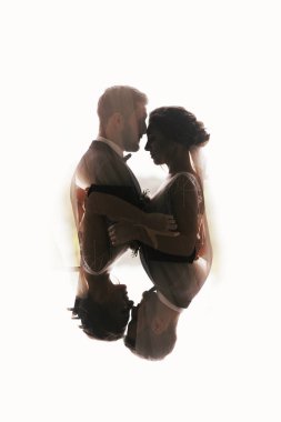 Muhteşem gelin ve şık damat siluetleri yavaşça sarılma. Çift Pozlama kucaklayan şehvetli düğün çift. Yeni evliler romantik anlar. Yaratıcı düğün fotoğraf