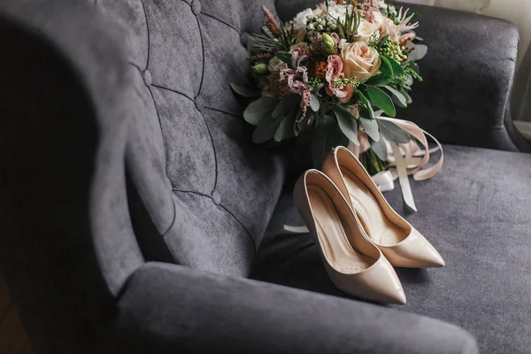现代婚礼花束 米色鞋和香水瓶在时尚灰色沙发上 婚礼日时尚新娘饰品的当代构成 — 图库照片