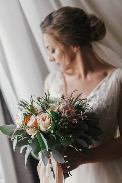 柔らかな光のウィンドウでポーズの花束と豪華な美しい花嫁 幸せな花嫁の笑顔と夢の完璧なメイクとスタイリッシュなドレスで ブライダルの朝 ロマンチックな瞬間 — ストック写真