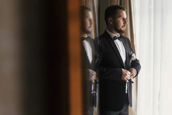 Stylish Groom Putting Suit Bow Tie Window Light Confident Happy — Stock Photo, Image