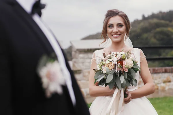 Preciosa Novia Con Ramo Moderno Mirando Novio Elegante Sonriendo Aire —  Fotos de Stock