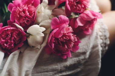 güzel pembe peonies bacak bohemian gelinlik boho kızın üzerinde. metin için yer. şık hipster kadın huysuz sabah çiçeklerle oturuyordu. atmosferik şehvetli an