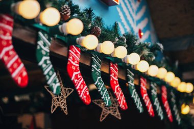 Şık Noel süsleri Avrupa şehri pazarında kabinler. Tatil çorap ve çorap, garland ışıklar ve köknar ahşap kabin dallarda. Şenlikli sokak dekor kış tatilleri